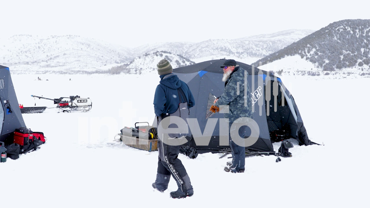 Talking in Ice Fishing Camp in Light Snow