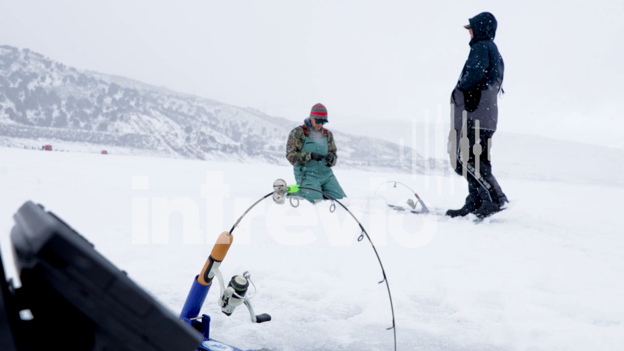 Two Men Ice Fishing in the Snow