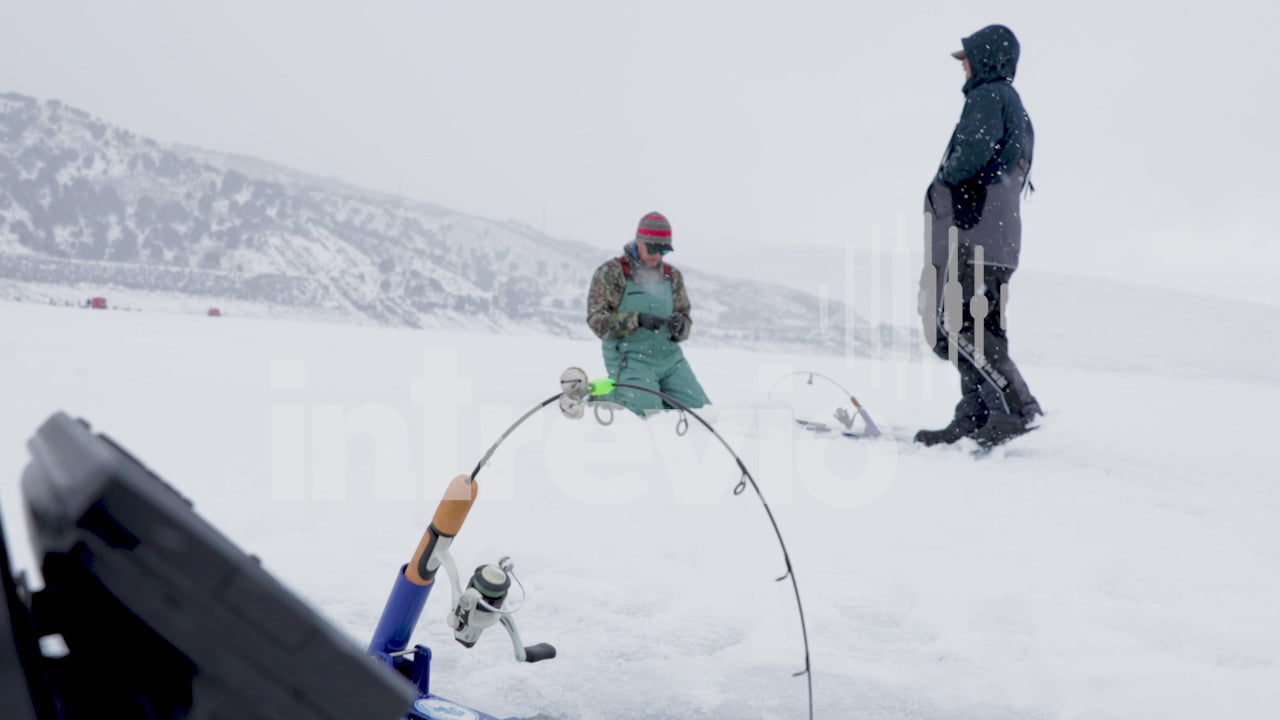 Two Men Ice Fishing in the Snow